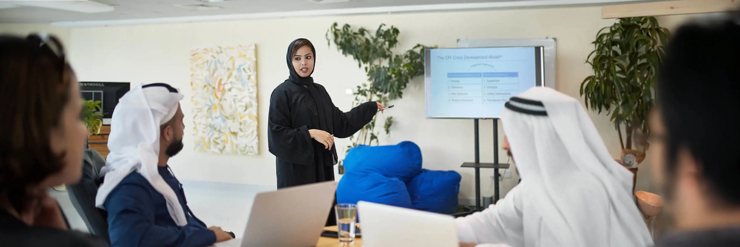 A woman in a hijab giving a presentation. 