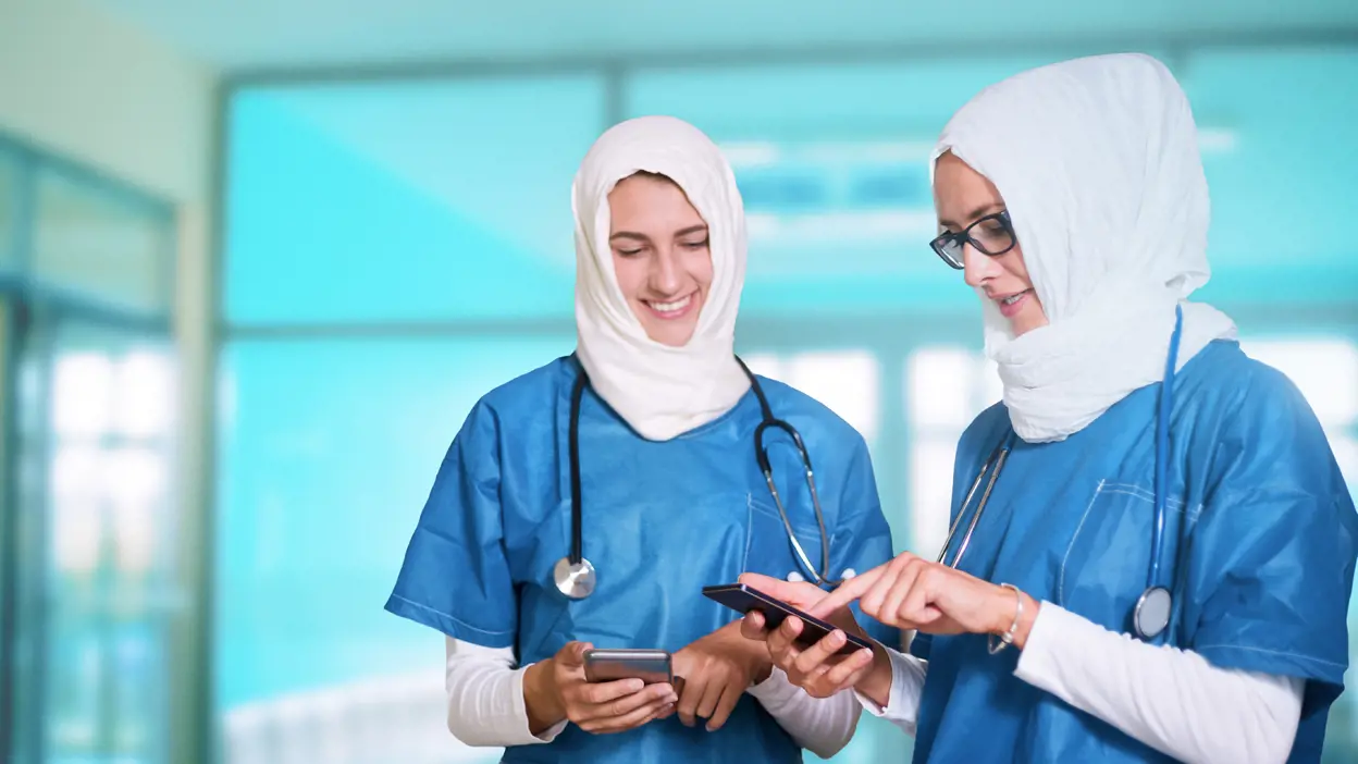 Two medical professionals looking at their mobile phones. 